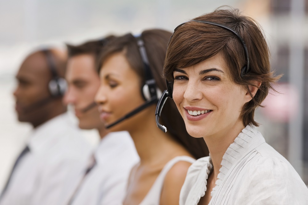 Closeup portrait of happy call center employees with headset